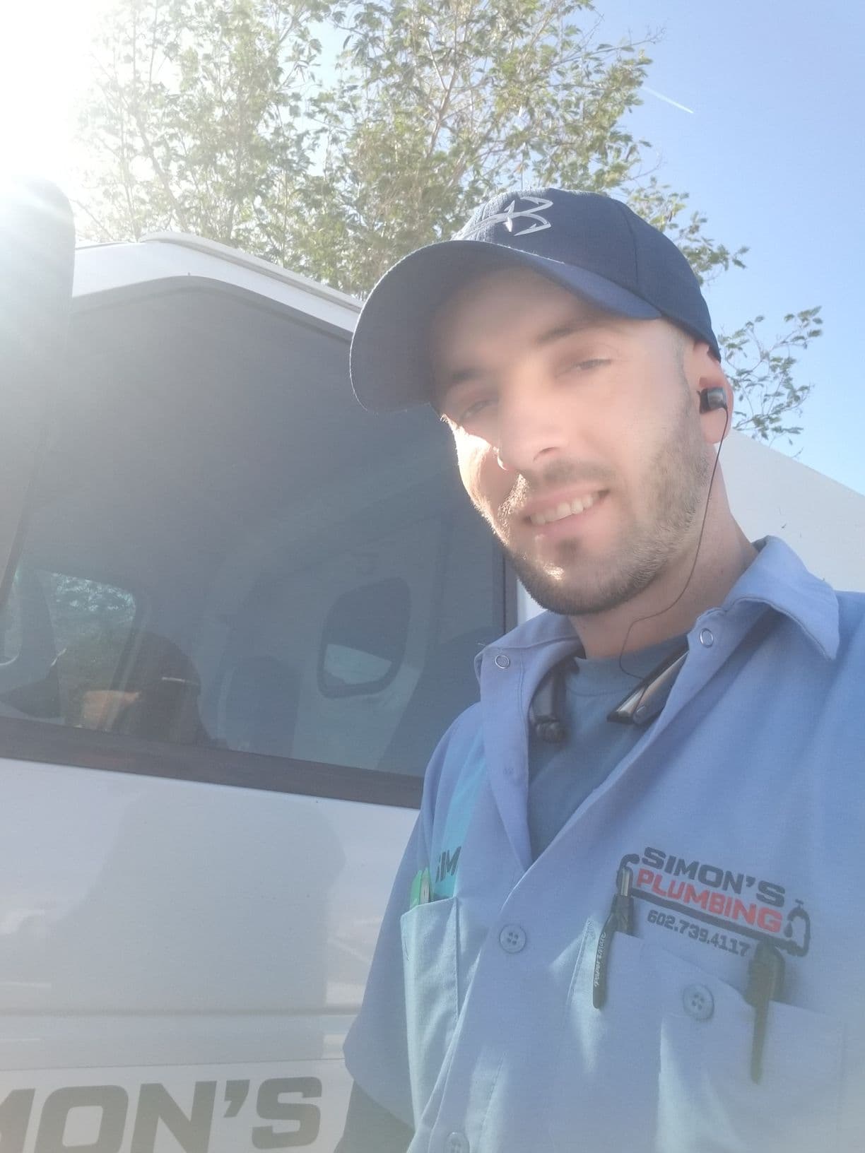 Simon Cupi standing in front of his branded Simon's Plumbing van